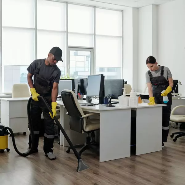 Deux individus utilisent un aspirateur pour nettoyer un bureau administratif, illustrant ainsi le service de nettoyage spécifique aux bureaux administratifs.