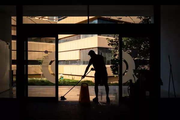 Un homme s'applique diligemment au nettoyage d'un bâtiment, assurant ainsi la propreté et l’ordre, y compris le nettoyage du sol.